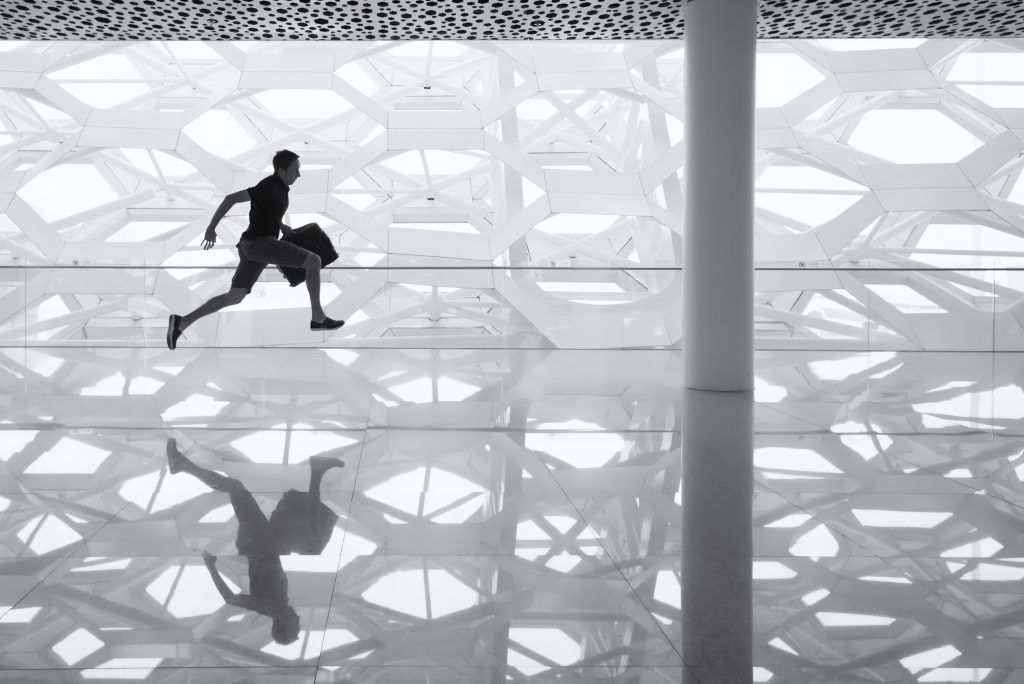 Una fotografía en blanco y negro de un hombre corriendo en un edificio.