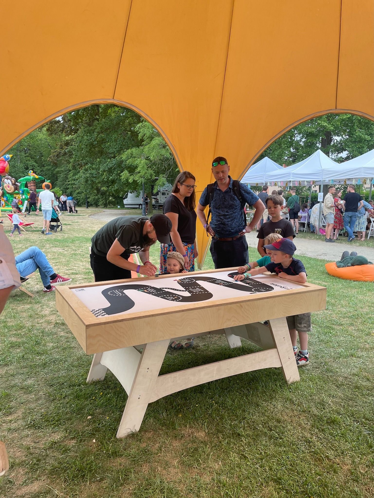 grupa ludzi stoi wokół stołu do gry