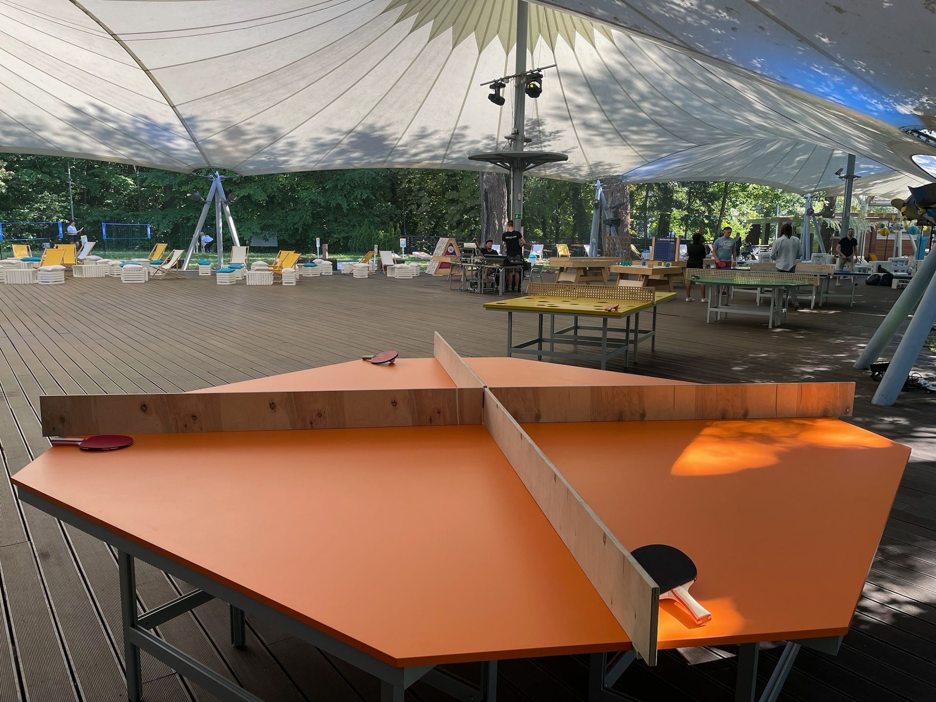 pod namiotem stół z dwiema rakietami do ping-ponga.