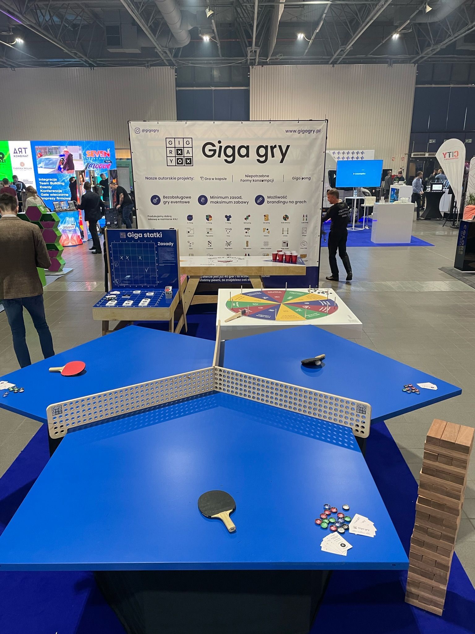 niebieski stół z rakietami do ping-ponga i napisem giga gry