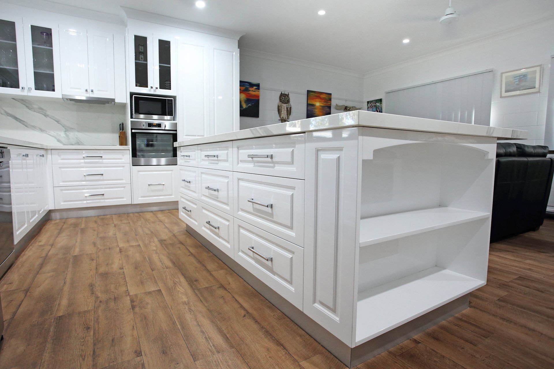 A kitchen with white cabinets and a large island in the middle of the room.