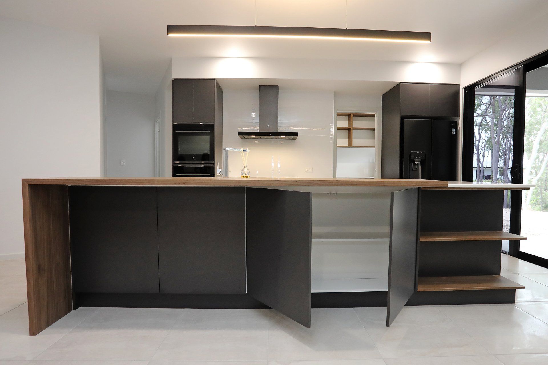 A kitchen with black cabinets and a wooden counter top