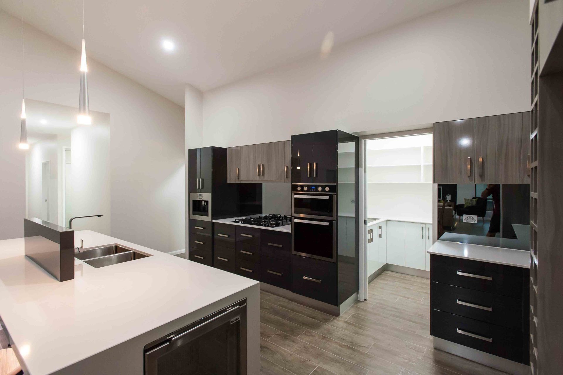 A kitchen with black cabinets and white counter tops