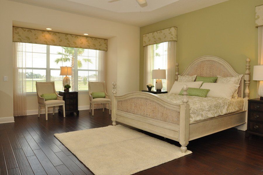 A bedroom with a bed , chairs , lamps and a rug