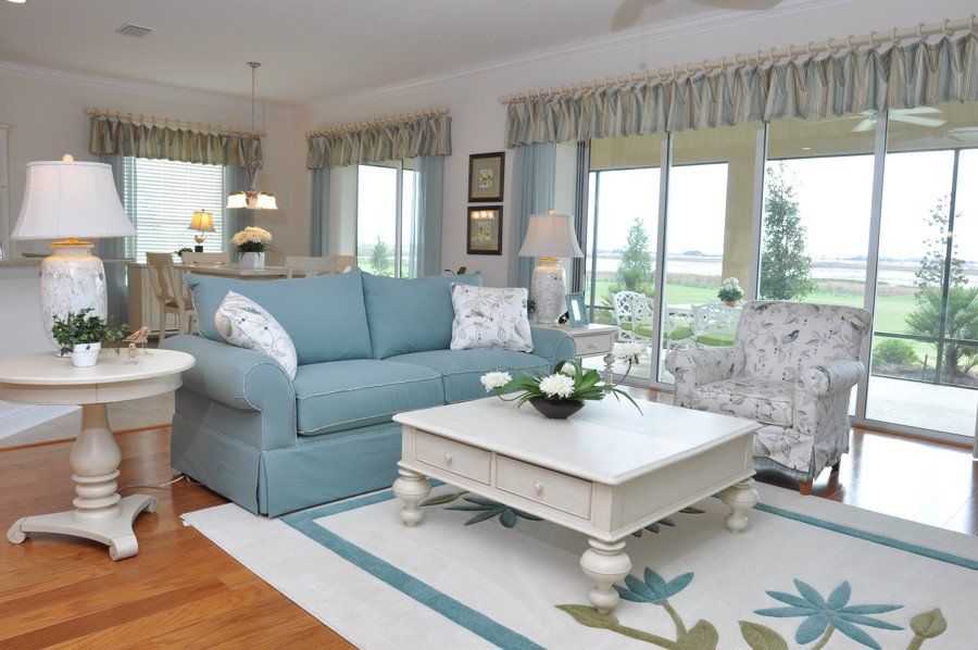 A living room with a blue couch and a white coffee table