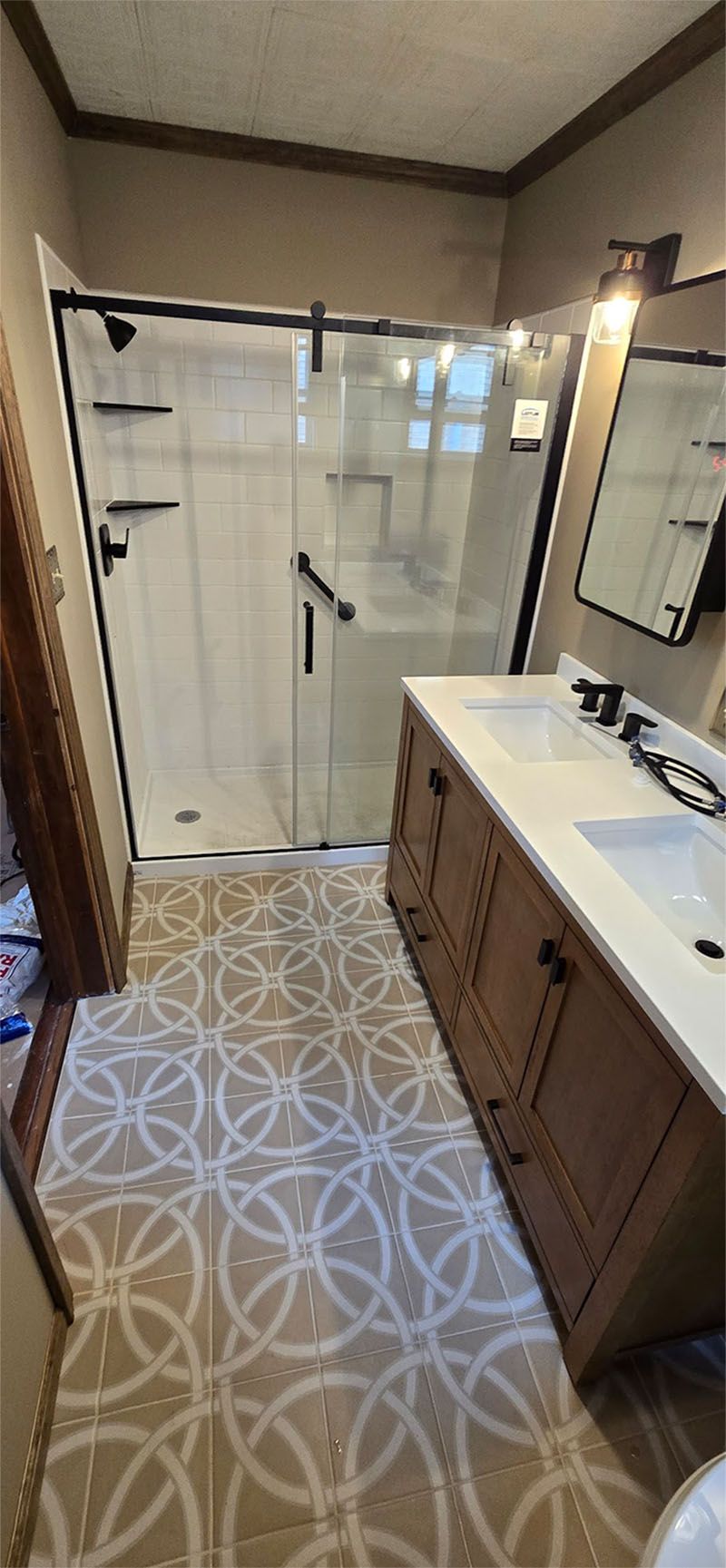 A bathroom with two sinks , a shower , and a mirror.