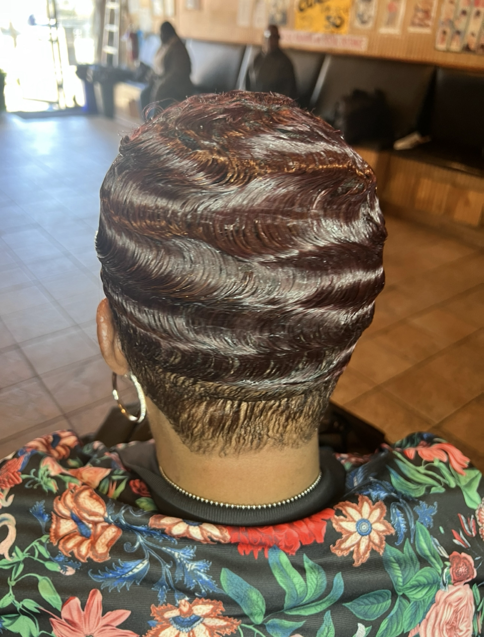 A woman with red hair is getting her hair cut in a salon.