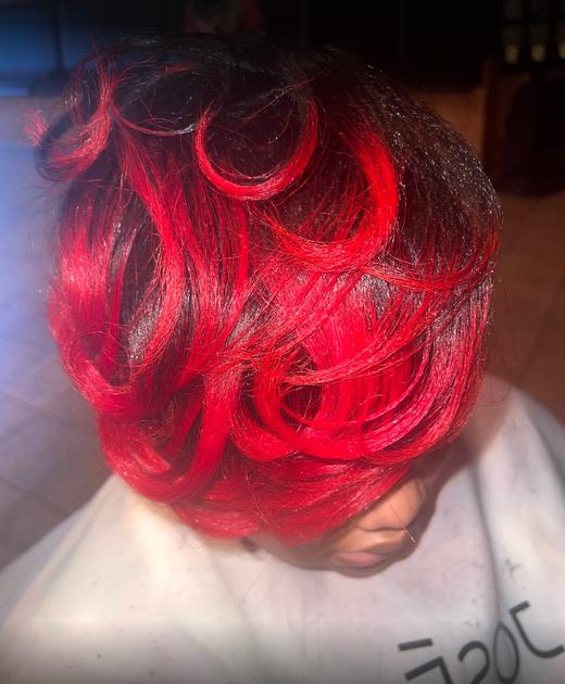 A woman with red hair is sitting in a chair.