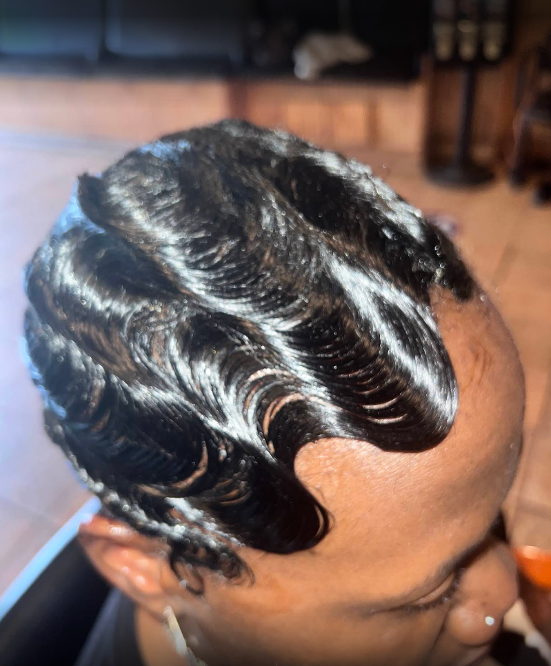 A close up of a woman 's head with wavy hair