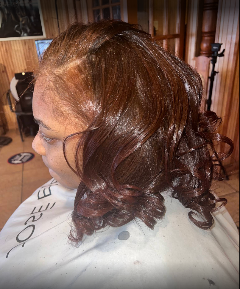 A woman is getting her hair cut in a salon.