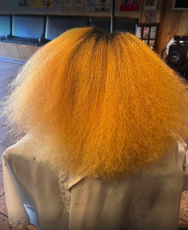 A woman with yellow hair is sitting in a chair.