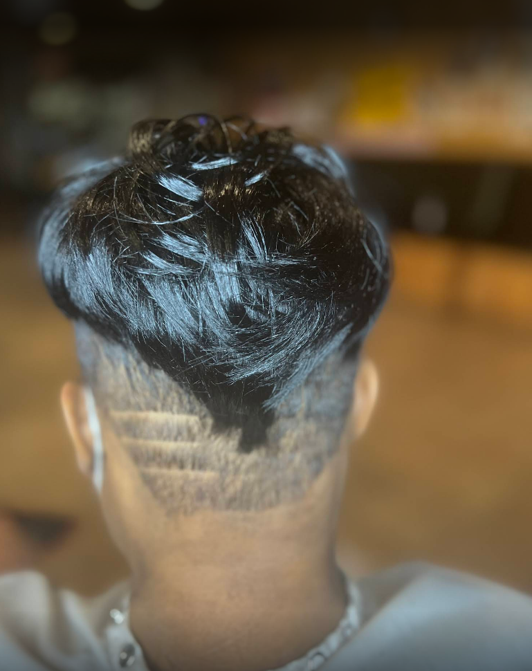 A close up of a person 's back with a shaved head.