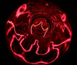 A close up of a red light bulb on a black background