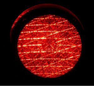 A close up of a red traffic light in the dark