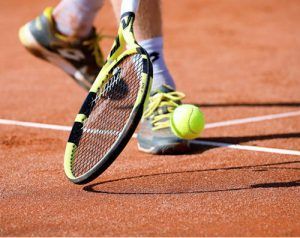 A tennis player is hitting a tennis ball with a racket