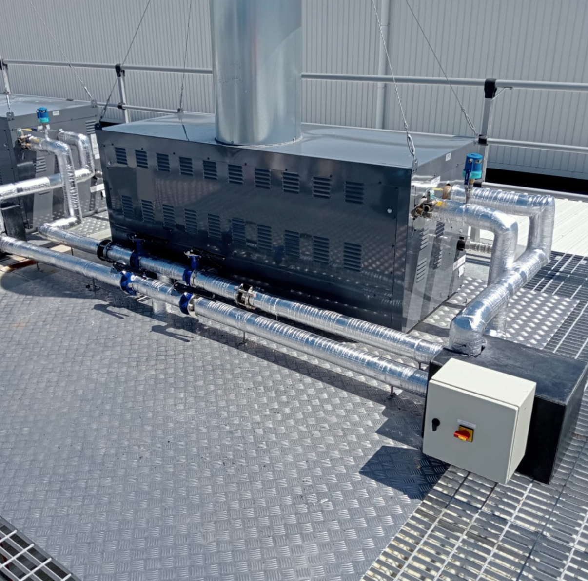 Hands in red and black work gloves using a screwdriver on a white appliance.