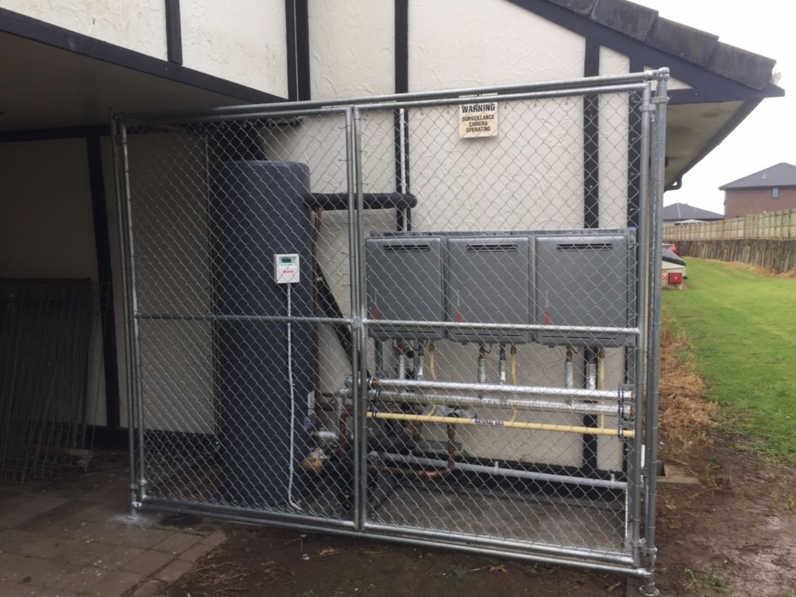 Gas valve connected to a yellow flexible gas line and a black appliance connector, set in a wood frame.