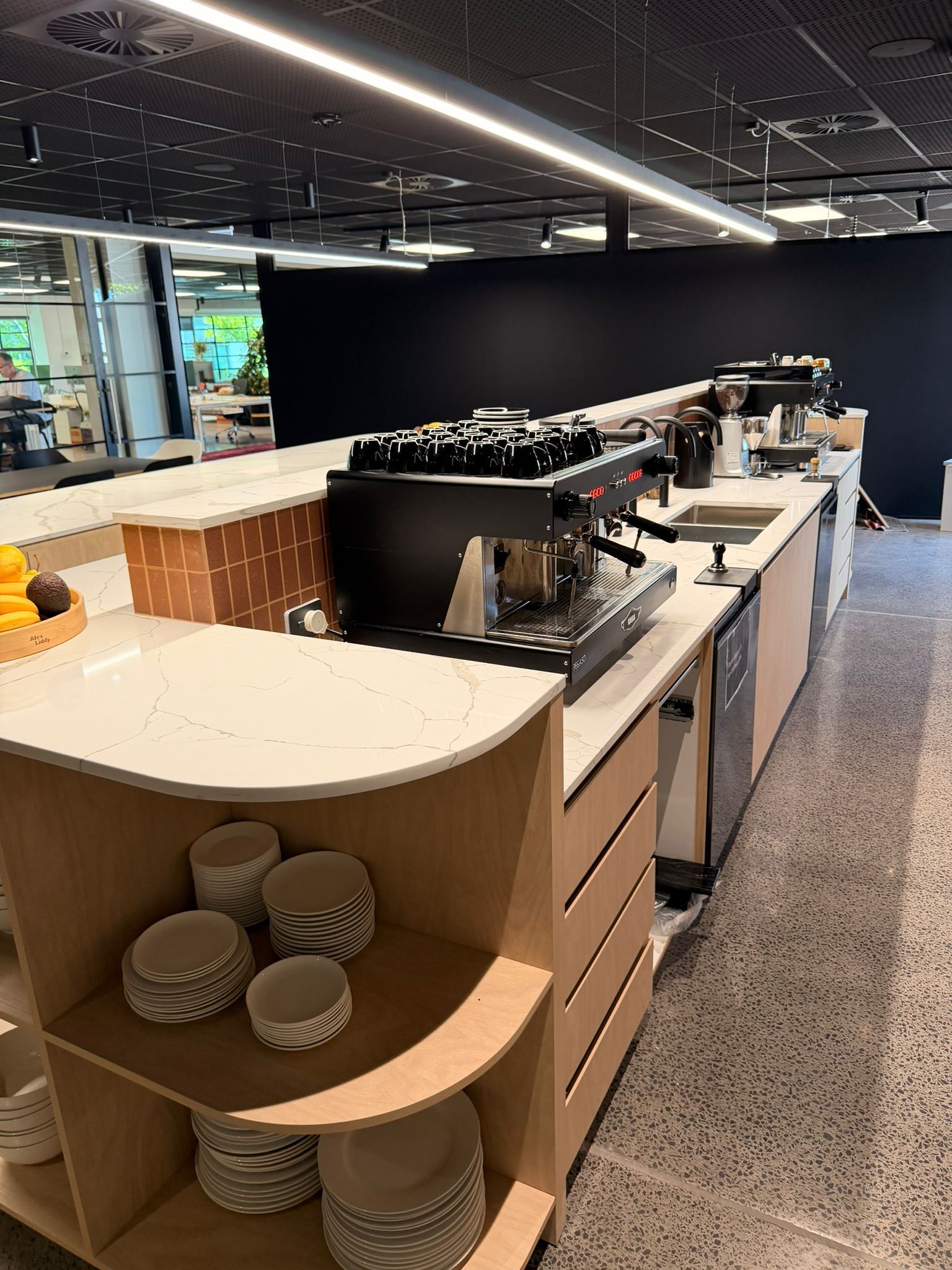 Black shower fixtures against a gray marble tiled wall.