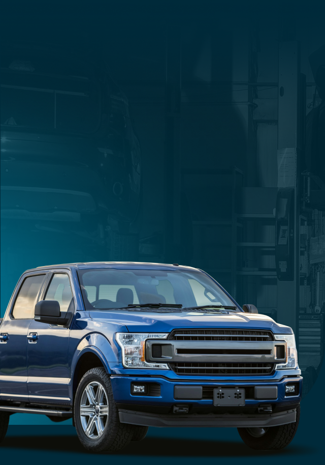 Blue pickup truck against a blue background, possibly an industrial setting.