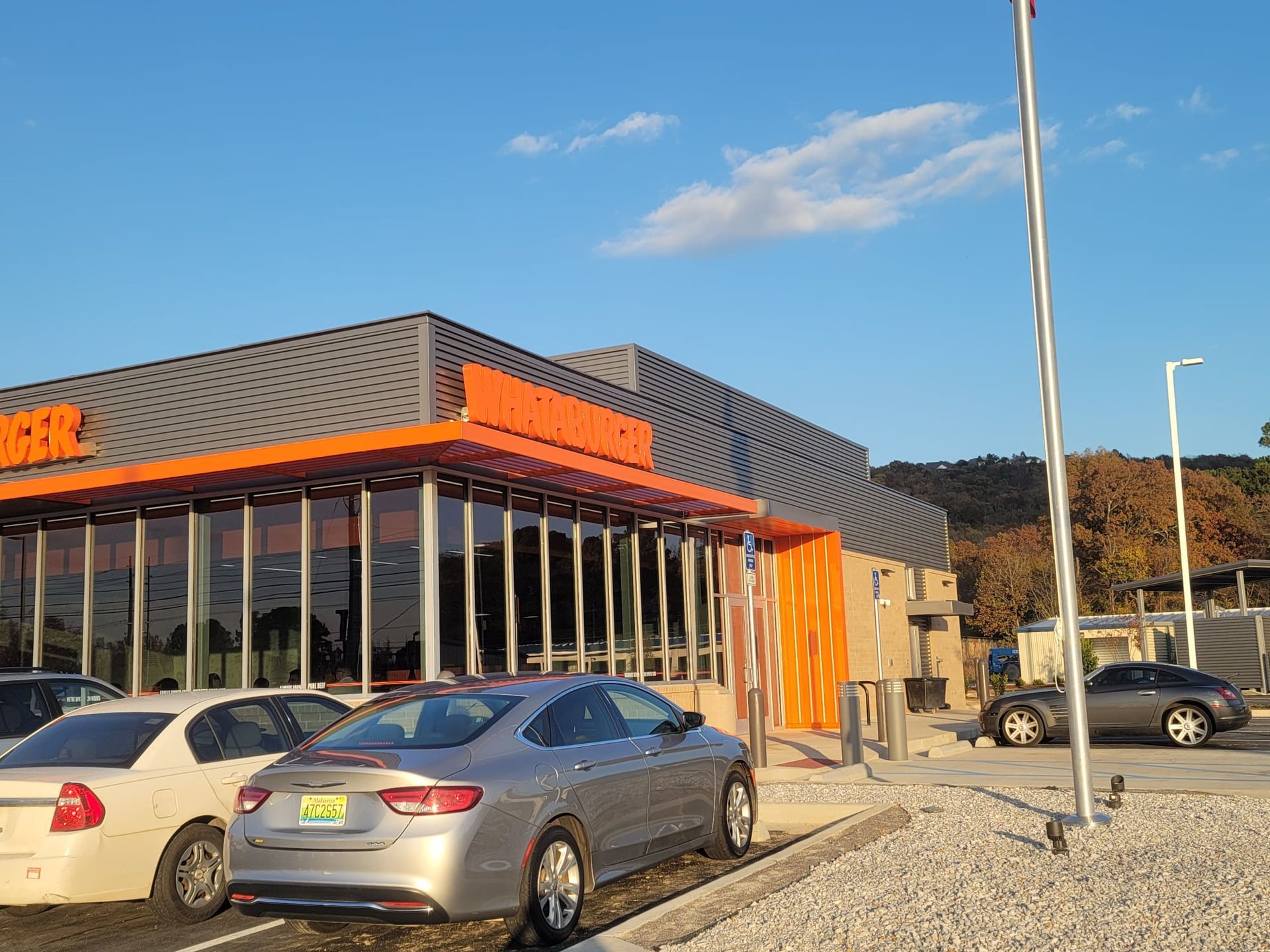 A silver car is parked in front of a building