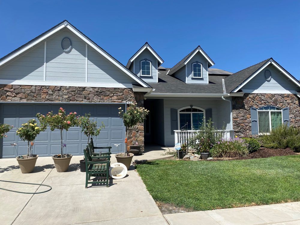 A large house with a lot of potted plants in front of it