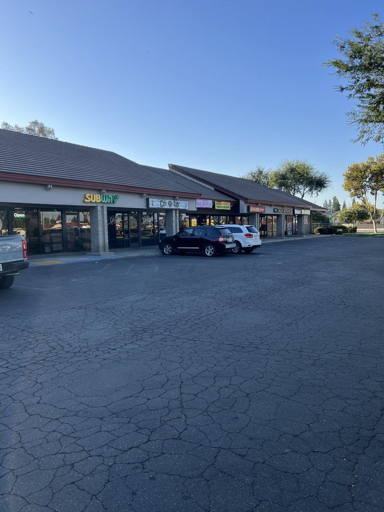 A lot of cars are parked in front of a building that says subway