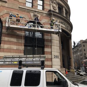 A white van is parked in front of a building with the number 290 on it