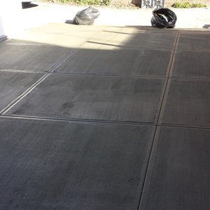 A concrete floor with a black trash bag on it.