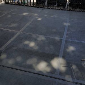 A shadow of a person is cast on a tiled floor