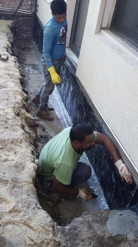 Two men are working on the side of a building.
