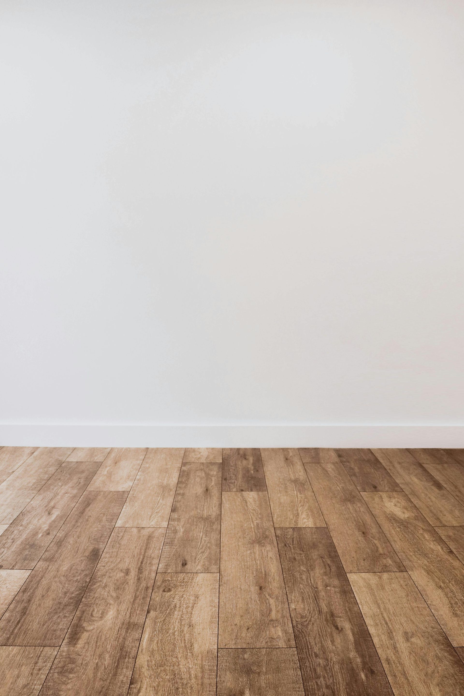 Empty room with white walls and wood flooring