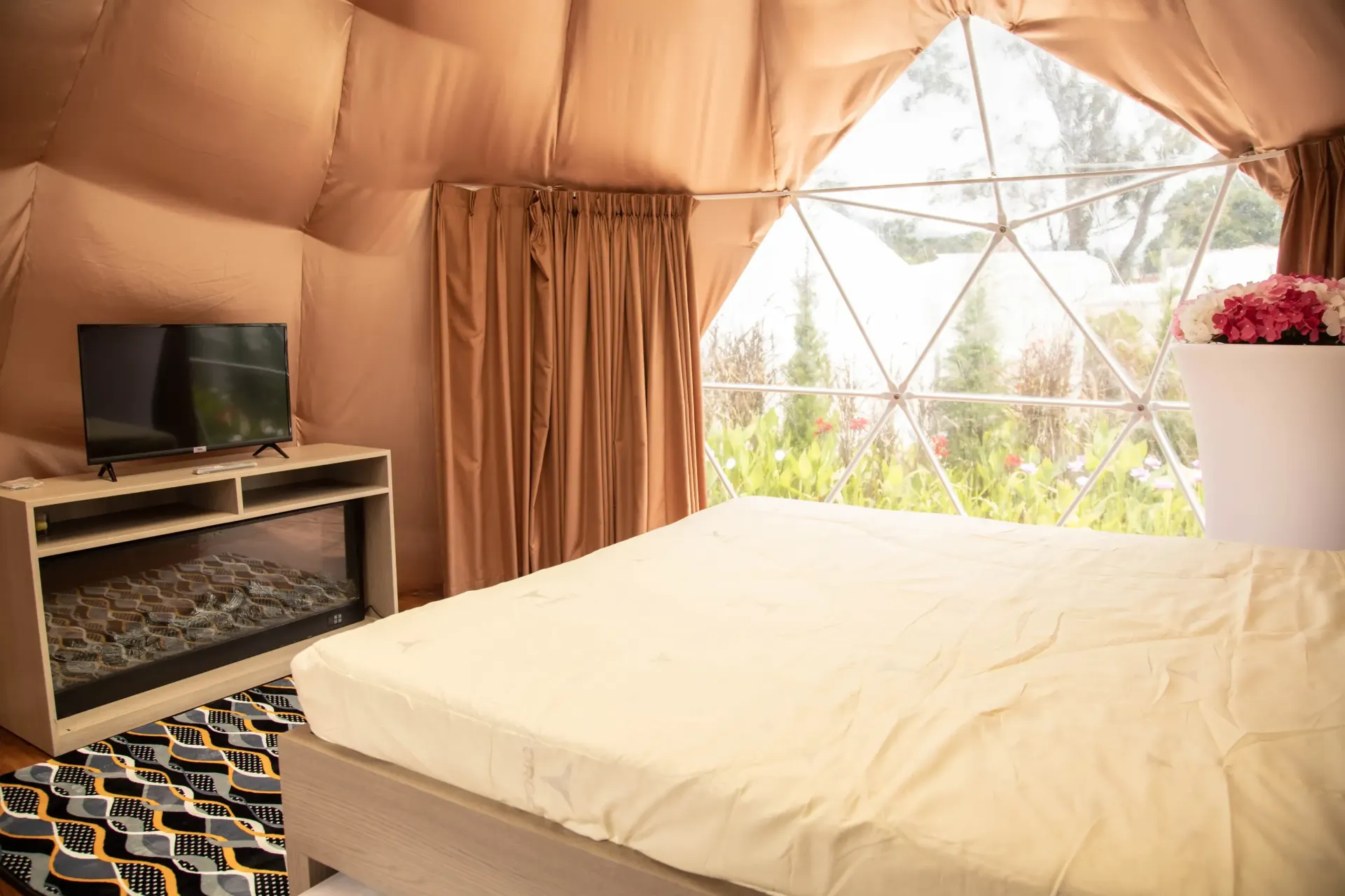 A bedroom with a bed , television and fireplace.