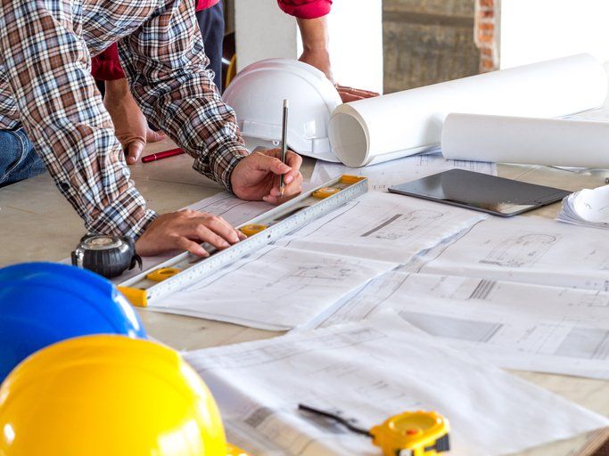 person working hands on table with blueprints