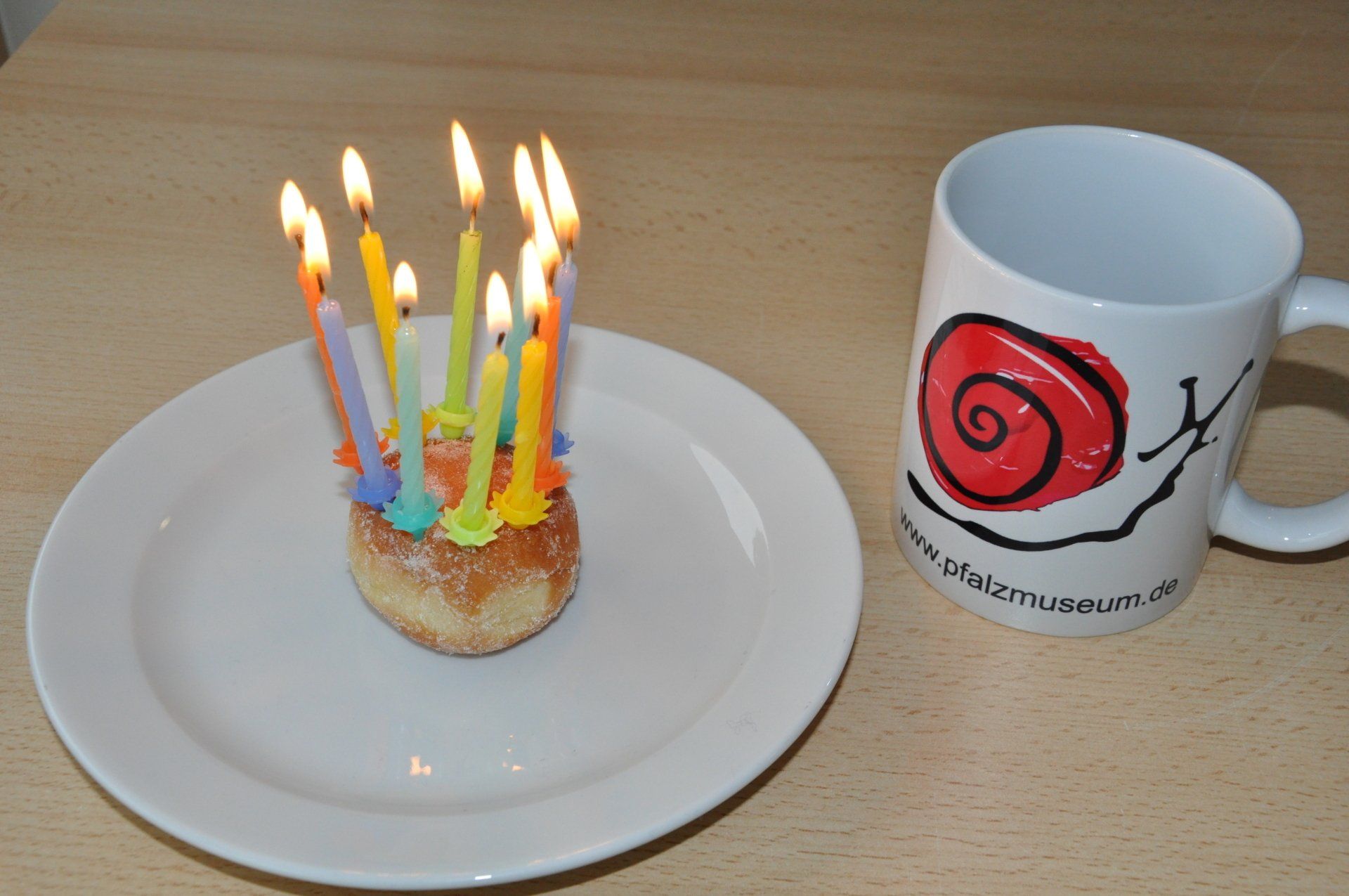 ein kleiner Kuchen mit vielen Geburtstagskerzen