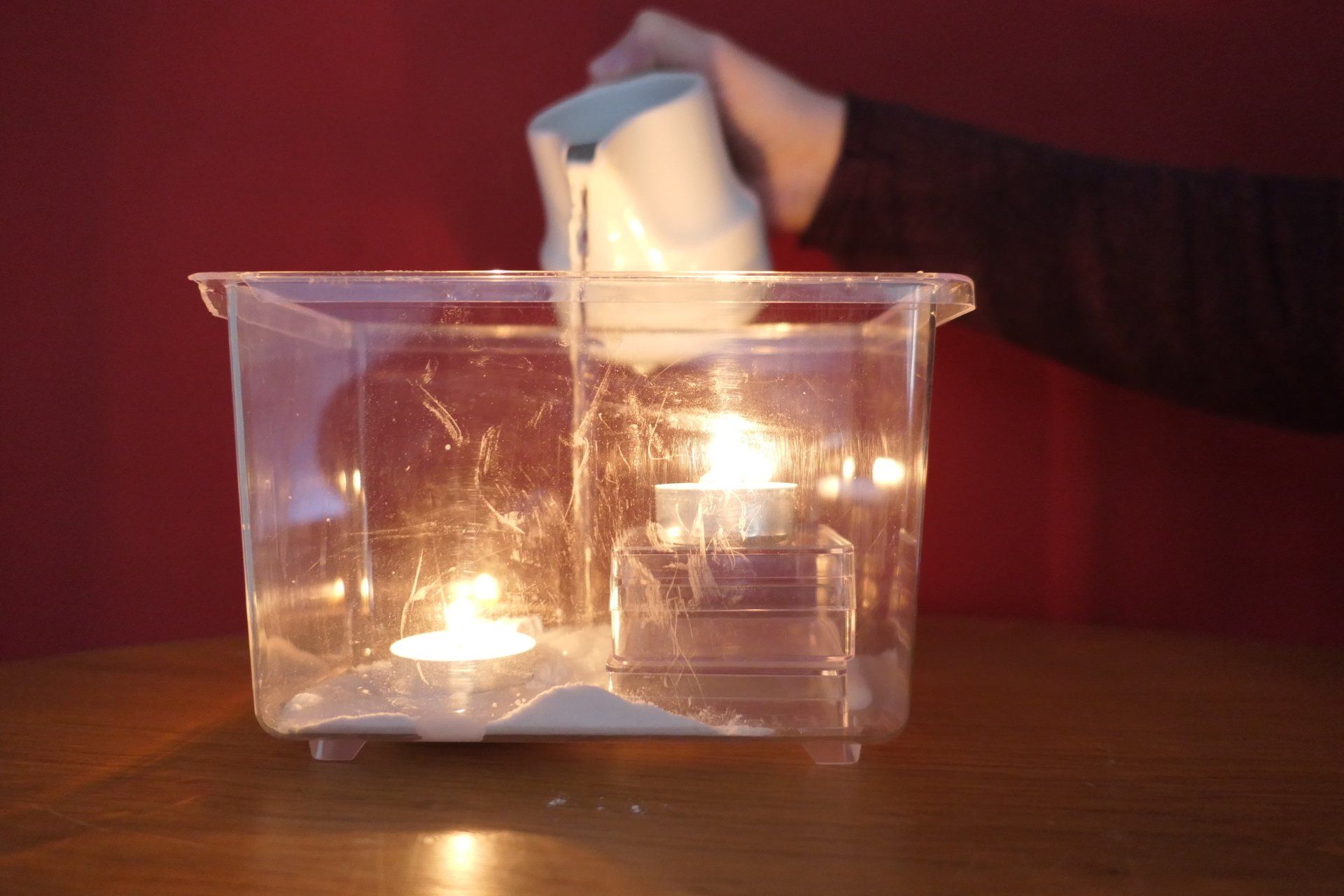 die Flamme eines Teelichts wird mit CO2, erzeugt durch Backpulver, gelöscht