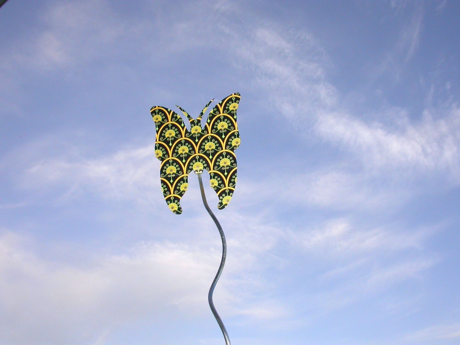 ein Schmetterling aus Pappe balanciert auf einer Metallstange