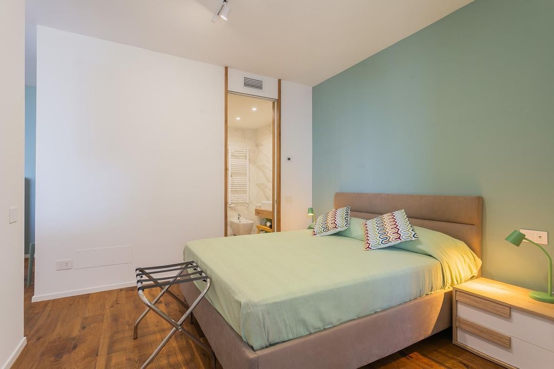 Quattro panettoni realizzati a mano, con guarnizioni diverse, allineati su una superficie metallica.