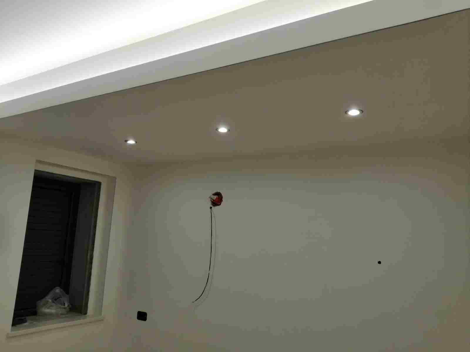 Una stanza vuota con luci incassate nel soffitto, una finestra e un allarme antincendio.