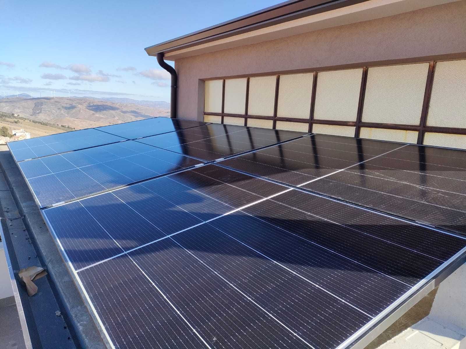 Pannelli solari installati su un tetto piano, contro un cielo terso e azzurro.