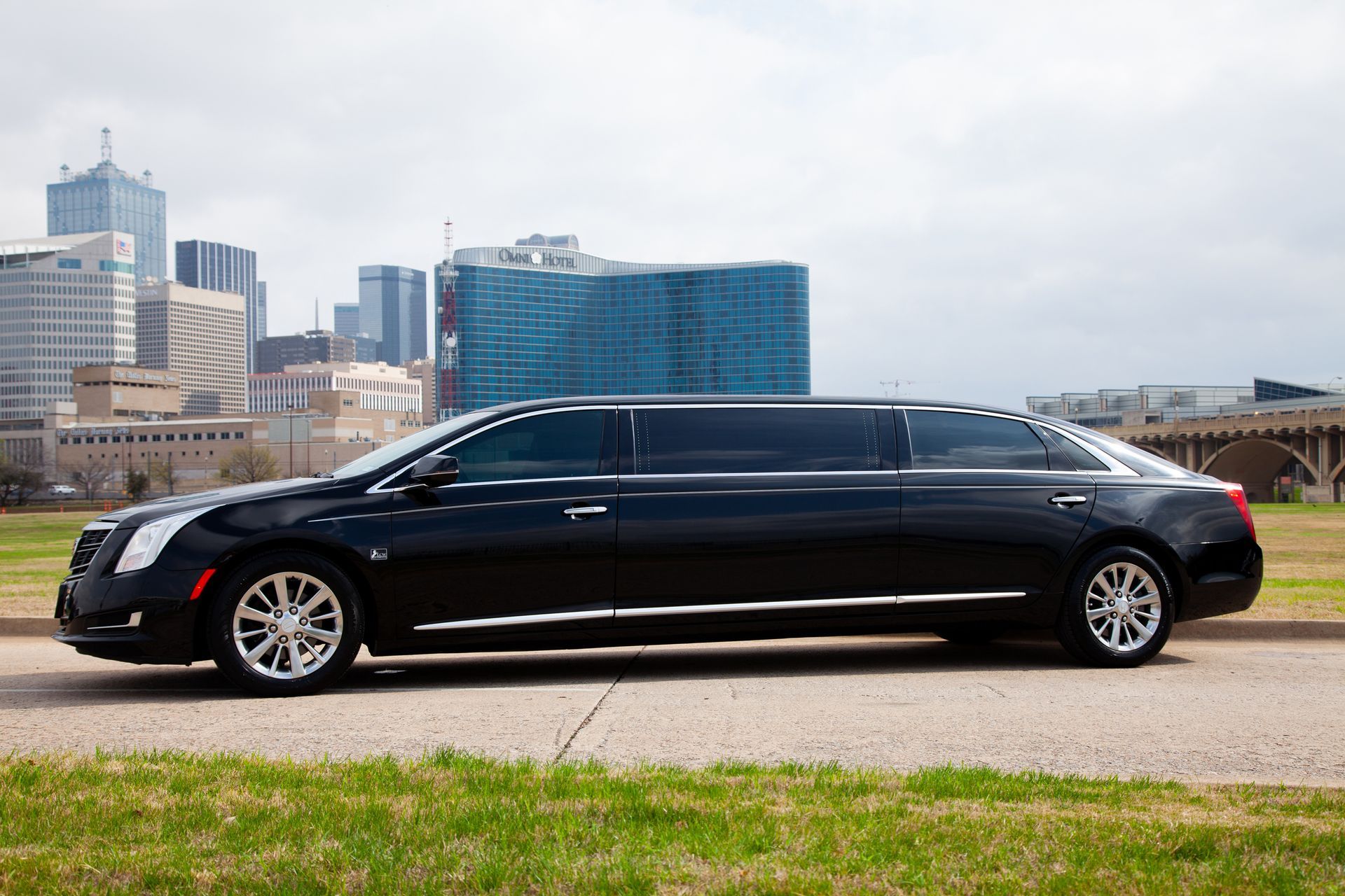 premier's black limousine is parked on the side of the road in front of a city skyline