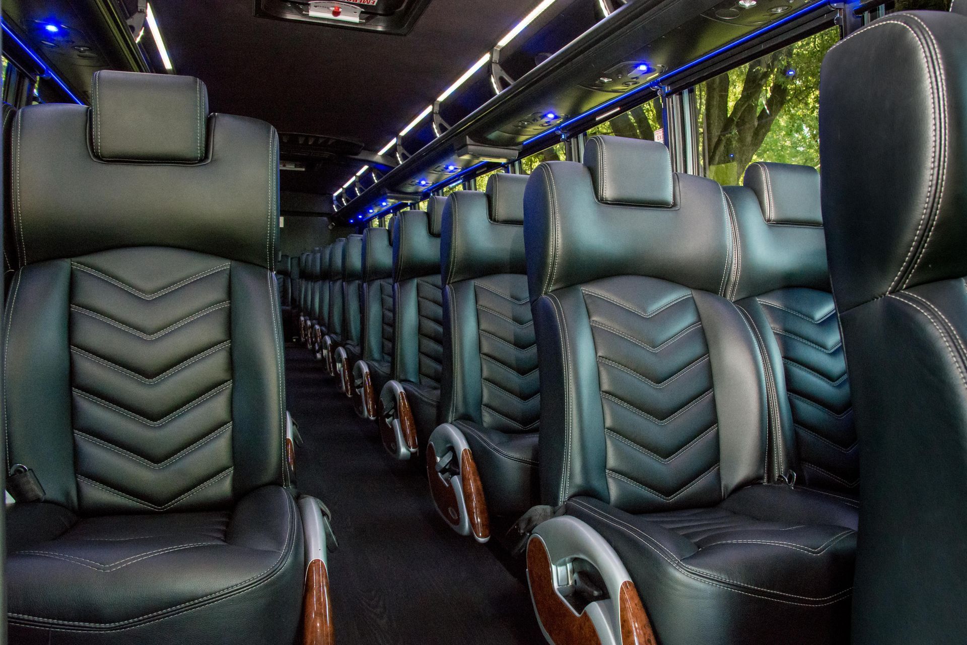 a row of black leather seats on premier's bus
