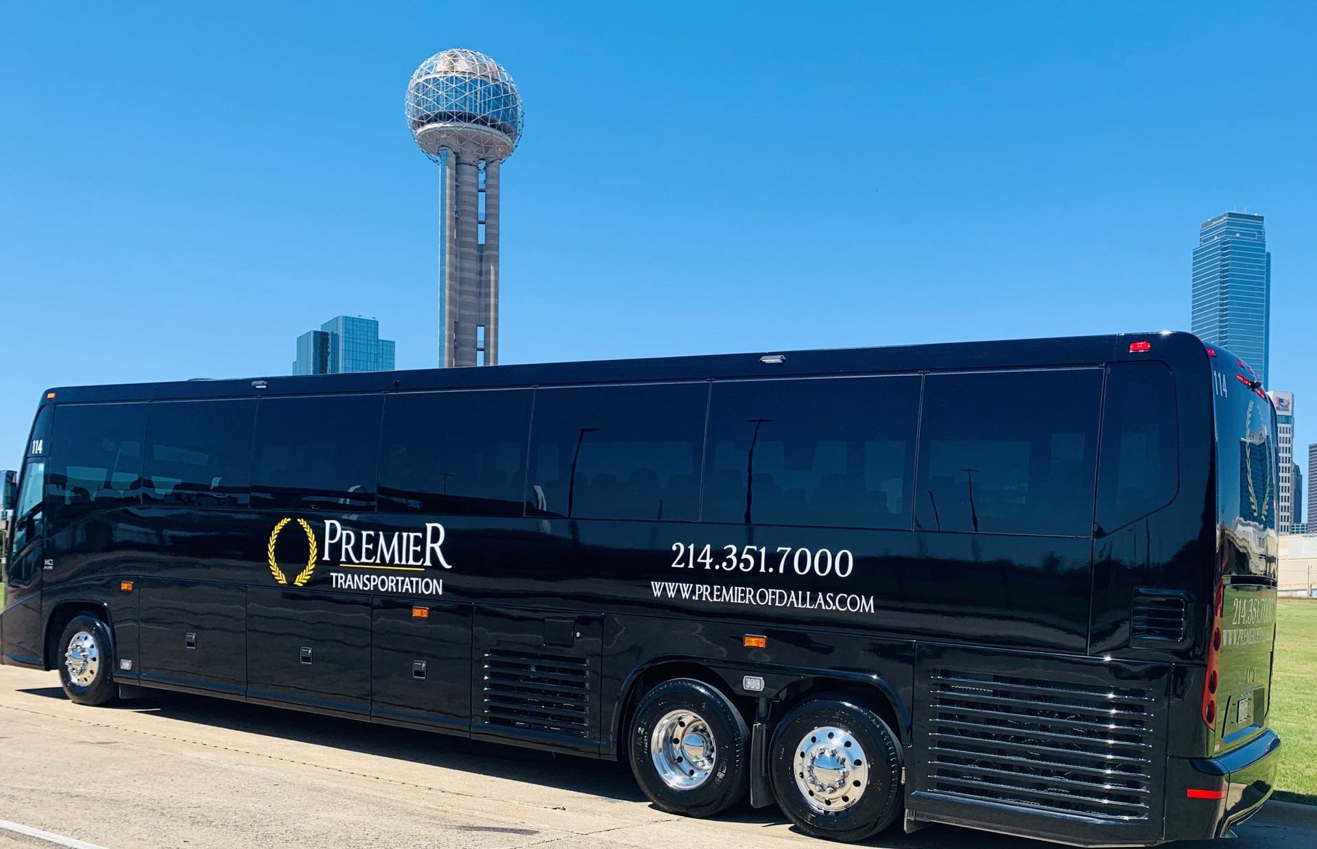 premier's black bus is parked in front of a tall building