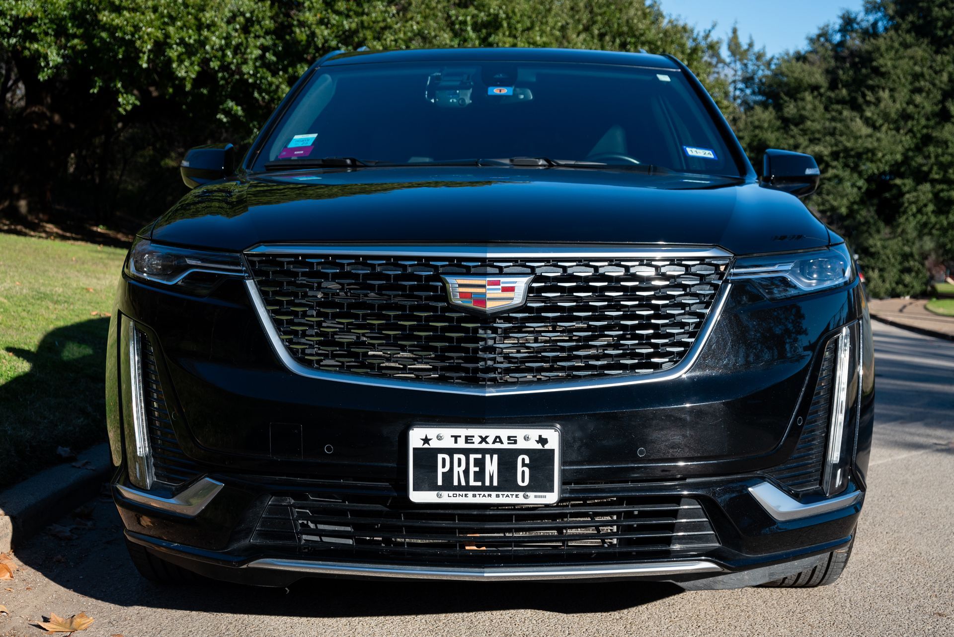 A black cadillac is parked on the side of the road.