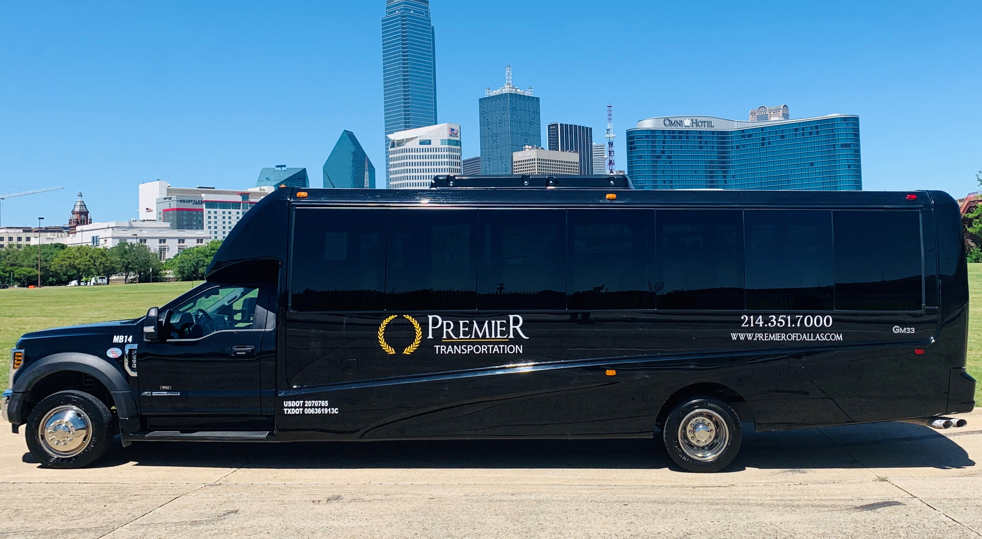 premier's black shuttle bus is parked in front of a city skyline