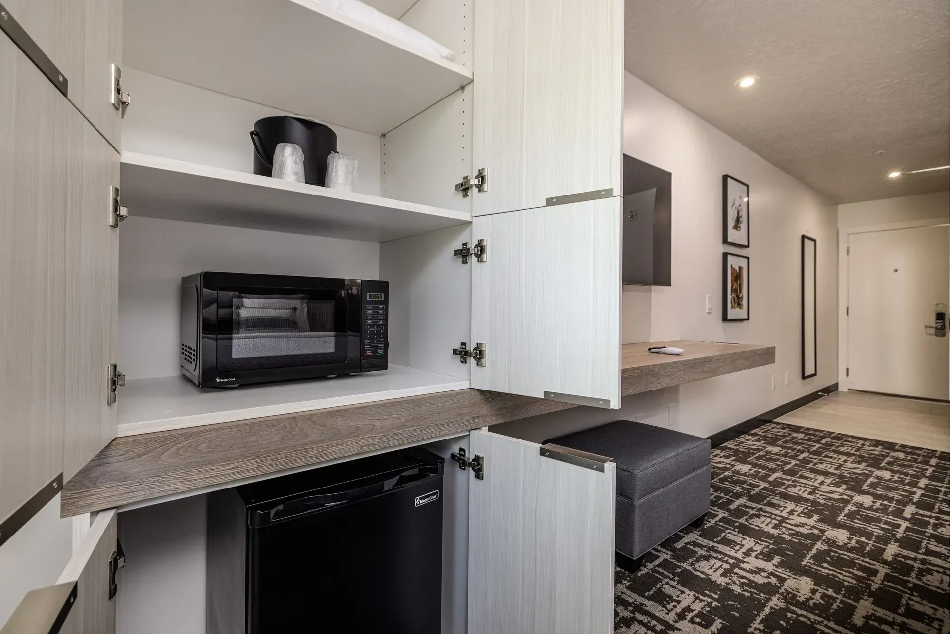 A hotel room with a microwave , dishwasher , and coffee maker.