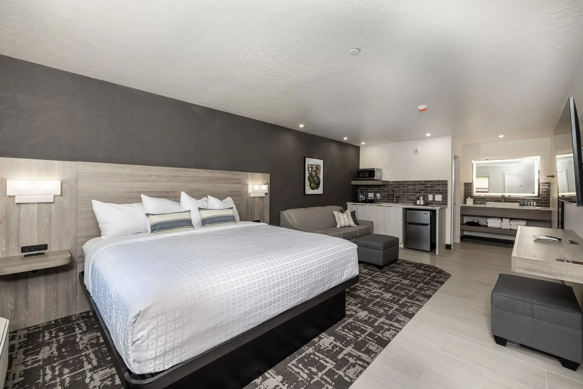 A hotel room with a king size bed and a couch.