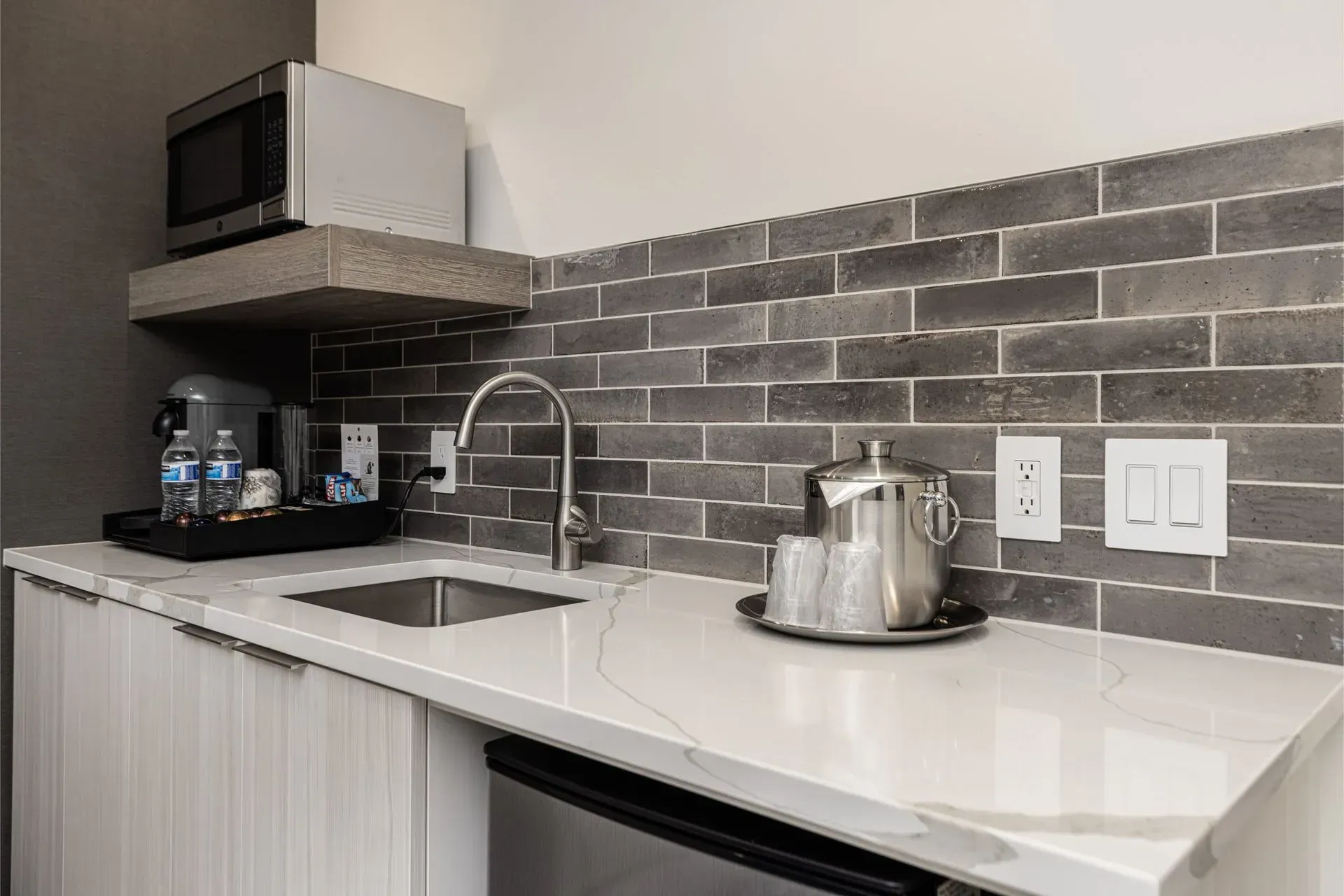 A kitchen with a sink , microwave , and dishwasher.