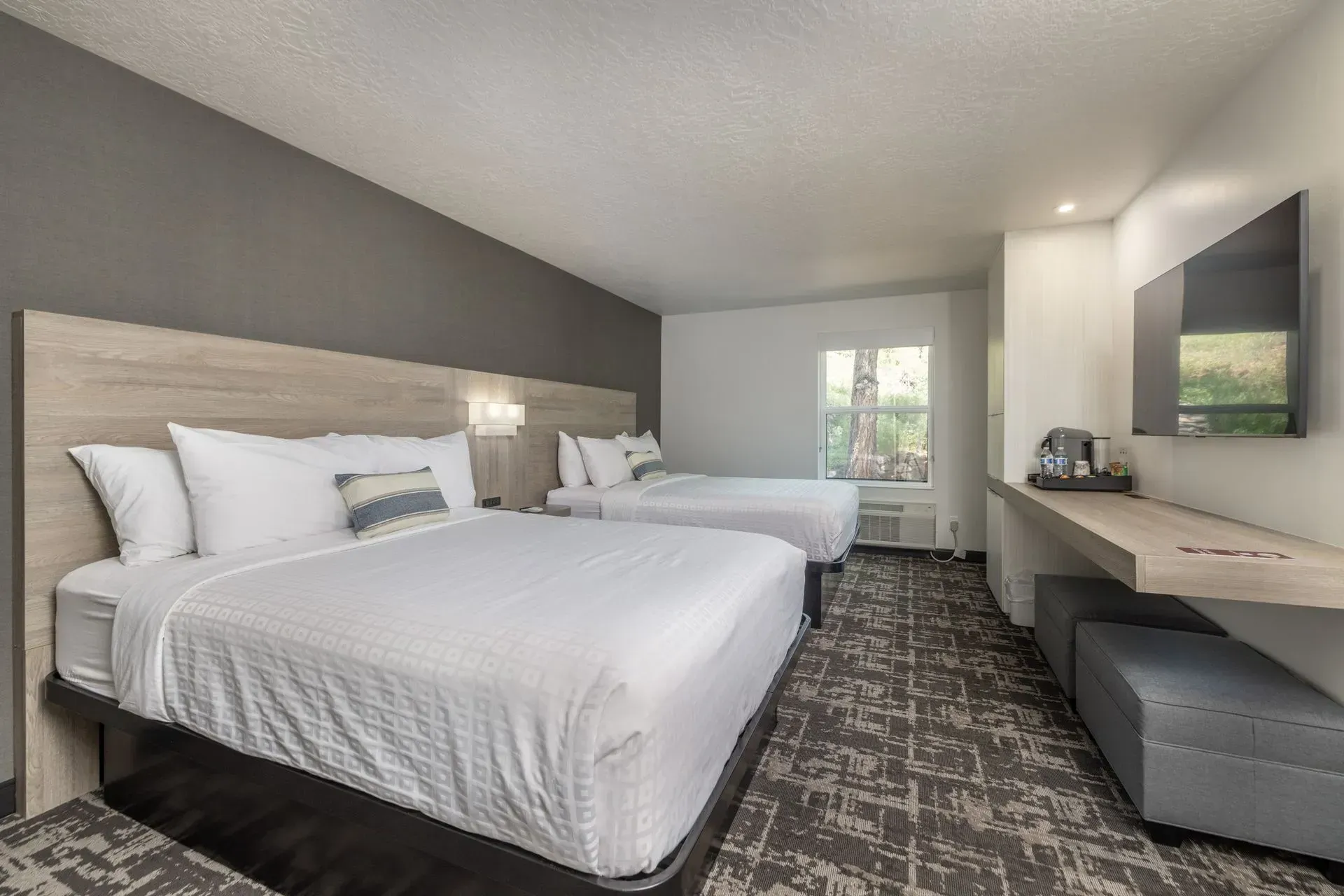 A hotel room with two beds and a flat screen tv.