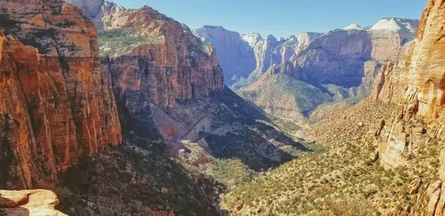 A view of a canyon with mountains in the background.