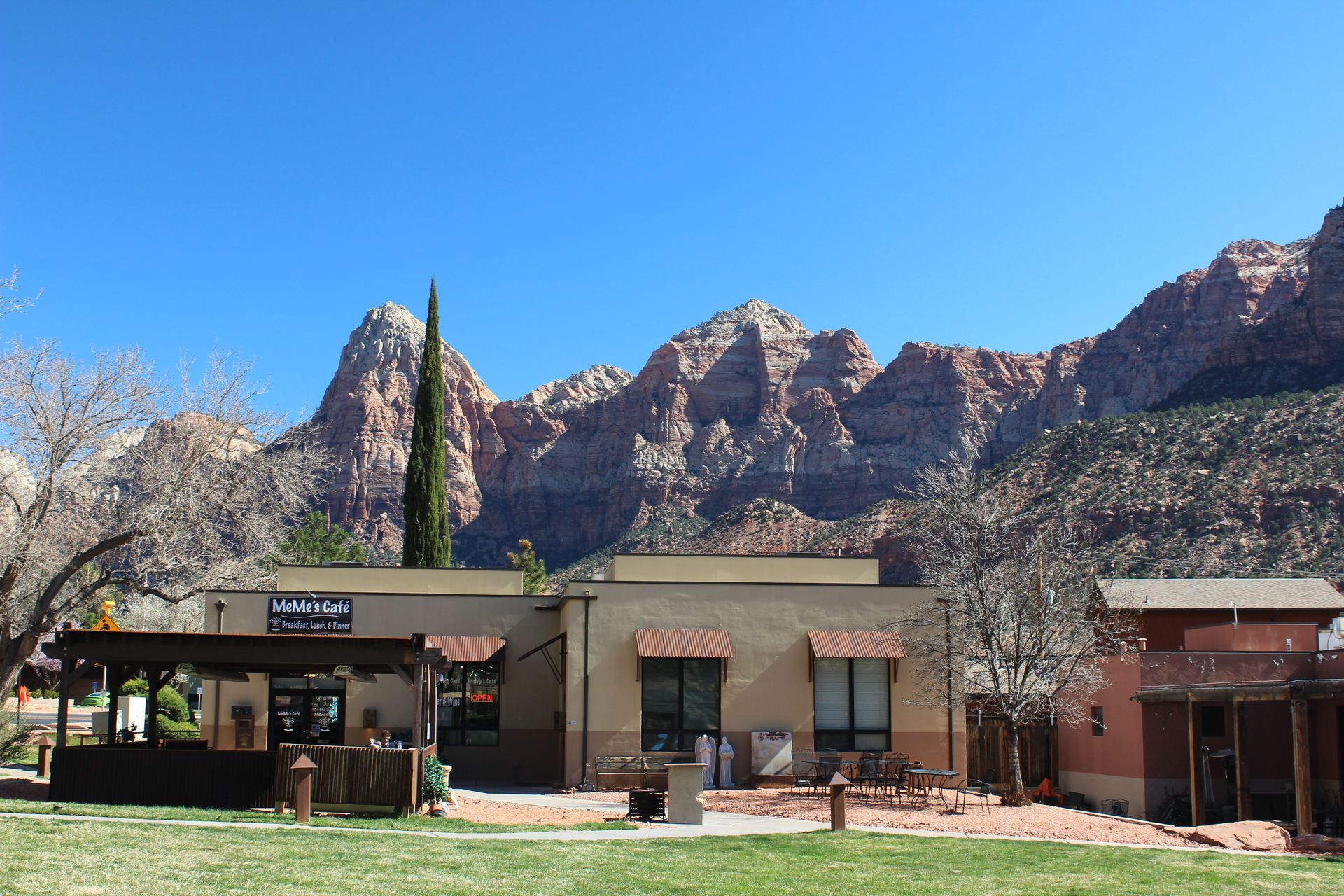 A building with a pergola in front of a mountain.